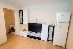 a living room with a tv and a refrigerator at Cris Apartament in Suceava