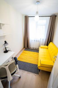a yellow couch in a room with a window at Cris Apartament in Suceava