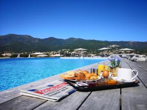 a tray of food on a table next to a pool at Hotel Residence Lido Marana Bastia Furiani in Furiani +44 photos