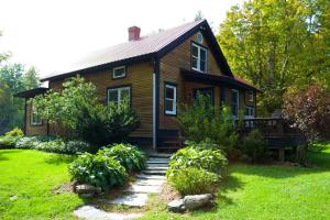 uma pequena casa de madeira com um jardim em frente em Sterling Ridge Resort em Jeffersonville