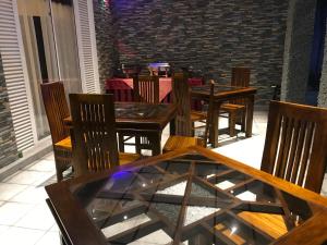 een eetkamer met houten tafels en stoelen bij villaflorence in Kadawata