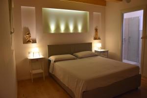 a bedroom with a bed with two night stands and two lamps at Suite In Centro Storico in Caorle