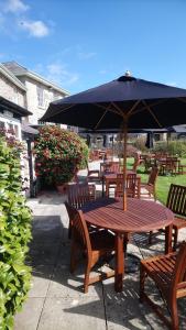 a wooden table and chairs with an umbrella at The Swan At Hay in Hay-on-Wye
