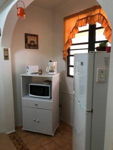 a small kitchen with a microwave and a refrigerator at Brisas Del Mar 1/1 Front Beach Apartment in Rincon