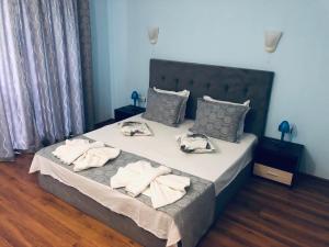 a bedroom with a large bed with towels on it at Guest House Stels in Kranevo