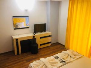 Habitación con 2 camas y escritorio con TV. en Guest House Stels, en Kranevo