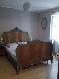 a bedroom with a large wooden bed in a room at appartement Vintage a l ancienne forge in Muhlbach-sur-Munster