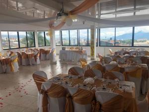 a banquet hall with tables and chairs in a room with windows at Hotel Santa Monica in Fusagasuga