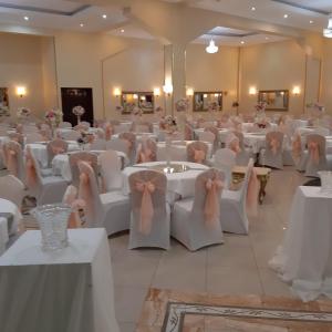 - une salle de banquet avec des tables blanches, des chaises et des bows dans l'établissement Numidien Hotel, à Alger