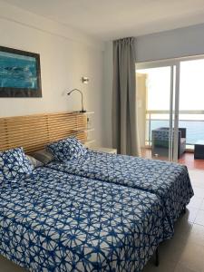 um quarto com uma cama com um edredão azul em Apartamentos Chinasolymar em Almuñécar