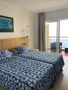a bedroom with a bed with a blue comforter at Apartamentos Chinasolymar in Almuñécar +34 photos