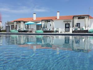 a swimming pool in front of a house at Terras - Agroturismo & Vinhos in Beja