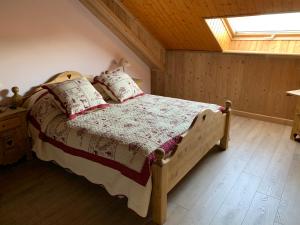 a bedroom with a wooden bed in a attic at L'écho des Artois in Uzelle