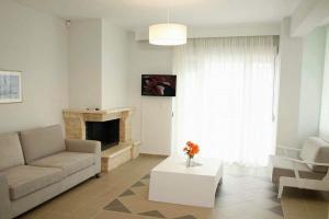 a living room with a couch and a fireplace at OLIVE & SEA in Nea Moudania
