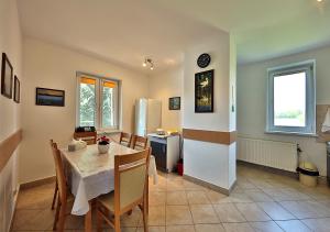 kuchnia i jadalnia ze stołem i krzesłami w obiekcie Apartamenty w Puszczy Boreckiej w Kruklankach