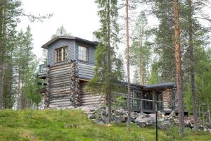 drewniany domek w lesie z drzewami w obiekcie Ankkalinna w mieście Pyhätunturi