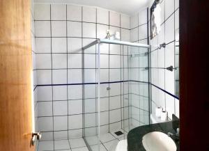 a white tiled bathroom with a sink and a shower at Acapu Hotel in Rio Verde +52 photos