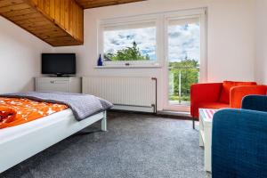 1 dormitorio con 1 cama, TV y silla en Willa Malinka, en Jastrzębia Góra
