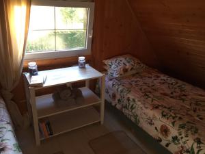 Кровать или кровати в номере Domek nad jeziorem Otalżyno