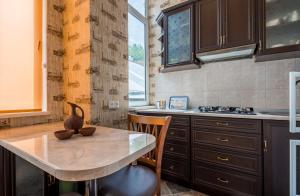 a kitchen with a table and chairs and a sink at MMA Apartment in Tbilisi City