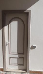 a white door with a window in a room at il Faro di Zancle, la Porta della Sicilia in Messina