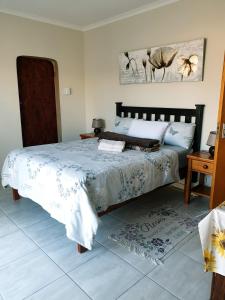 a bedroom with a bed with a blue and white comforter at Sunflower Self-Catering in Walvis Bay