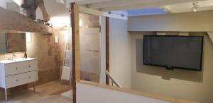 a bathroom with a tv on the wall and a sink at La Cabane in Penne-dʼAgenais +15 photos