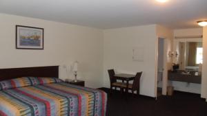 a hotel room with a bed and a table and a desk at Deluxe Inn Palacios in Palacios