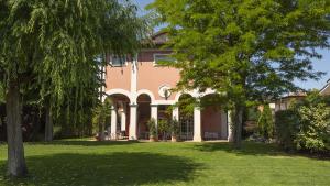 モデナにあるVilla Matildisの庭の木々が植えられた大ピンクの家