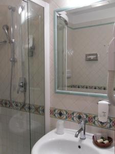 y baño con lavabo y ducha con espejo. en Best Western Hotel Dei Cavalieri, en Barletta