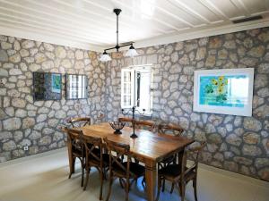 a dining room with a wooden table and chairs at Urania Luxury Villa Geofos in Póndi