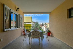 a table and chairs on the balcony of a house at Apartments Srzentic in Petrovac na Moru