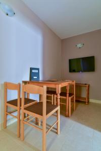 a dining room with a table and chairs and a flat screen tv at Apartments Srzentic in Petrovac na Moru