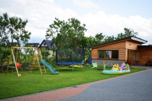 a backyard with a playground and a house at Pokoje i Apartament u Lucyny in Czarna Góra