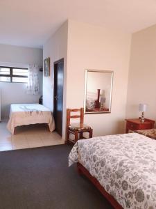a bedroom with a bed and a mirror and a chair at Sunflower Self-Catering in Walvis Bay