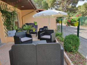 a group of chairs and an umbrella on a patio at Kyriad Direct Marseille Ouest - Martigues in Martigues