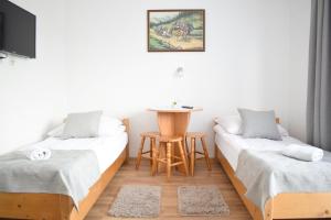 um quarto com duas camas e uma mesa em Pokoje i Apartament u Lucyny em Czarna Góra