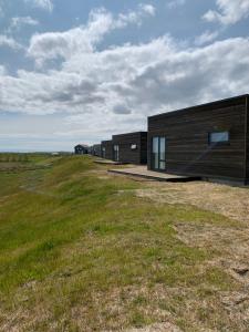 un bâtiment dans un champ avec un champ herbeux dans l'établissement Heima Holiday Homes, à Selfoss