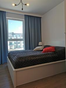 a bedroom with a bed with a large window at Apartament Bel Mare Pelikan in Międzyzdroje