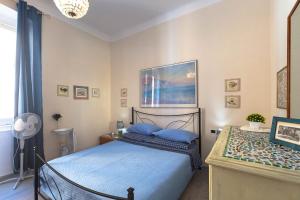 ein Schlafzimmer mit einem Bett mit blauen Kissen in der Unterkunft Un balcone tra il cielo e il mare in Camogli