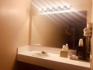 a bathroom with a sink and a large mirror at Bryce Way Motel in Panguitch