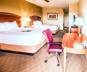 a hotel room with two beds and a desk and a chair at La Quinta by Wyndham Marble Falls in Marble Falls