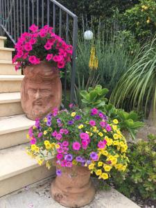 un jarrón lleno de flores sentado en las escaleras en Mastrissa Country House, en Taormina