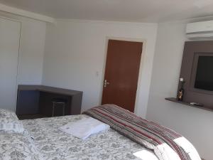 um quarto com uma cama e uma televisão na parede em Apartamento Santa Ana em São Joaquim