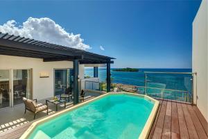 a swimming pool on a deck with a view of the ocean at Grand Lido Negril Au-Naturel, An Autograph Collection All-Inclusive Resort - Adults Only in Negril