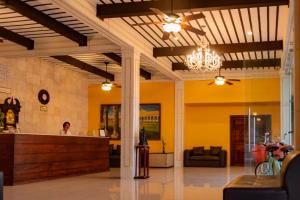 a lobby with a counter and a person in the background at Hotel Tuul in Izamal