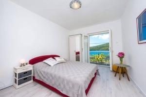 a white bedroom with a bed and a window at Villa Lara in Molunat