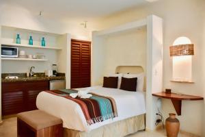 a bedroom with a large bed and a kitchen at Playa Palms Beach Hotel in Playa del Carmen