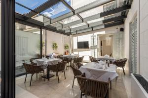 a dining room with tables and chairs and windows at Residence Stine in Split
