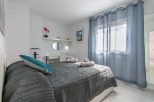 une chambre avec un grand lit avec des rideaux bleus dans l'établissement LA ESTRELLA 1A020, à Los Cristianos 26 autres photos